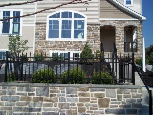 aluminum fence installed on top of a stone wall