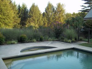 textured bronze aluminum pool fence installation protects a backyard pool