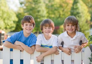 Kids on white wooden fence