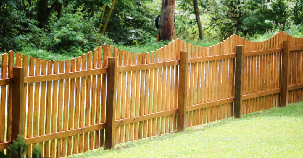 Curved top wood picket fencing in backyard