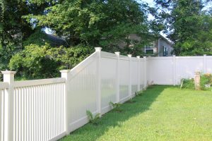 White vinyl privacy fence installed on incline