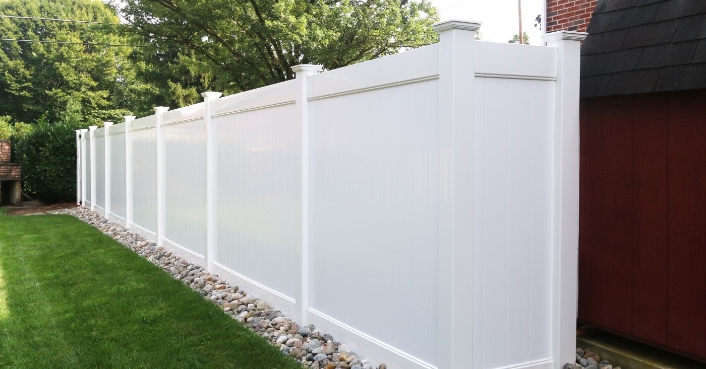 Classic traditional tall white privacy fence in backyard