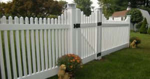 white vinyl modern fence design in backyard in front of a shed